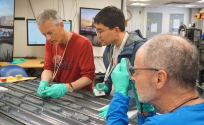 Three researchers analysing different sized rocks 